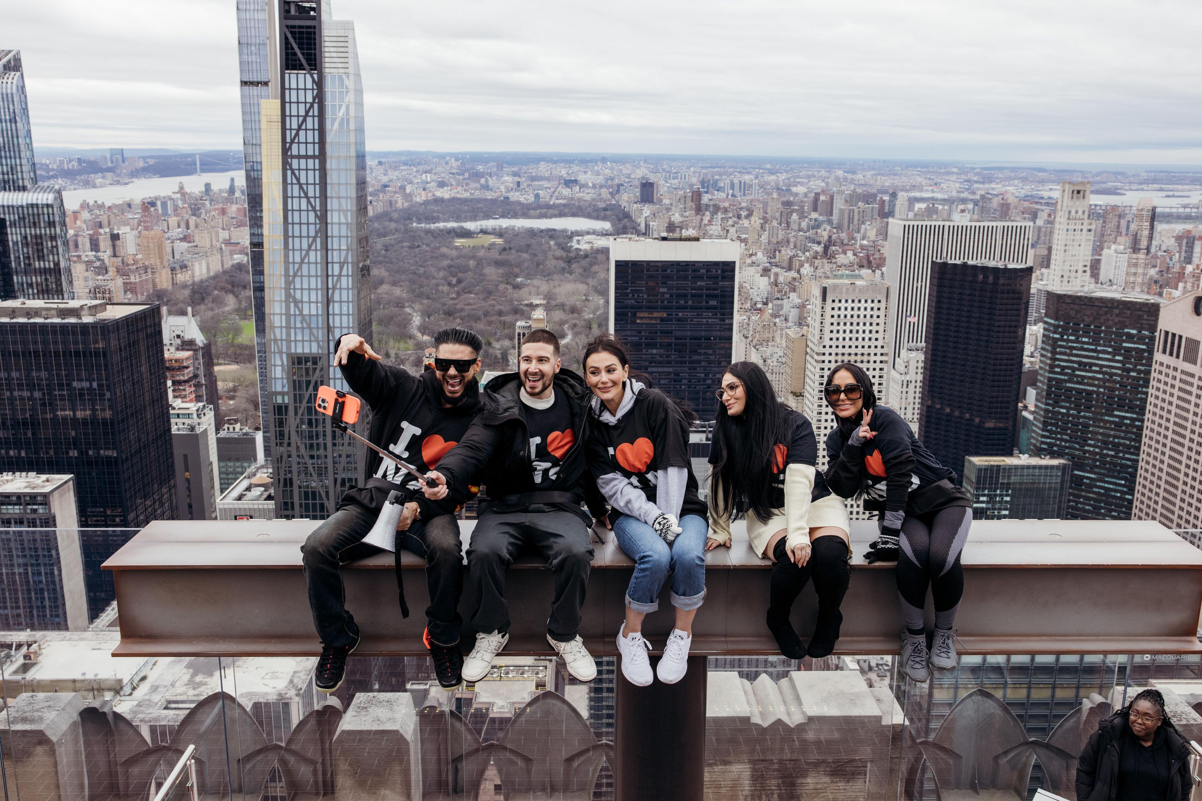 the cast of jersey shore on the beam at top of the rock