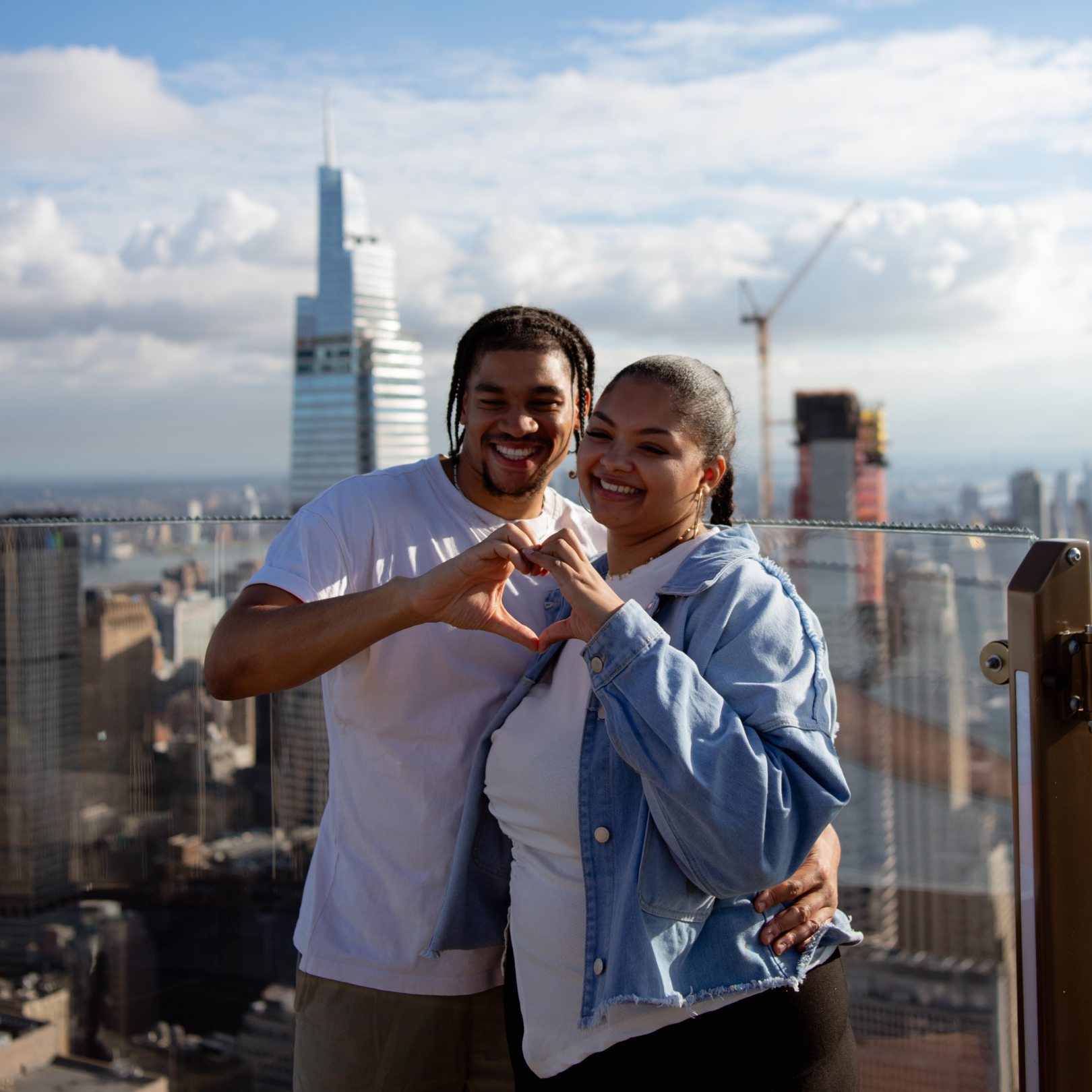 A couple posing for a photo on SKYLIFT at Top of the Rock