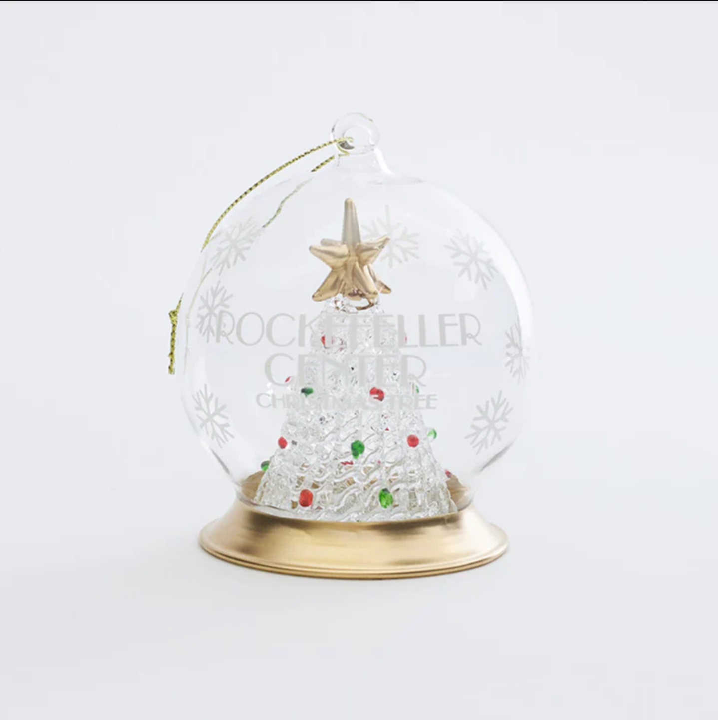 A snowglobe ornament with the rockefeller center christmas tree in the center