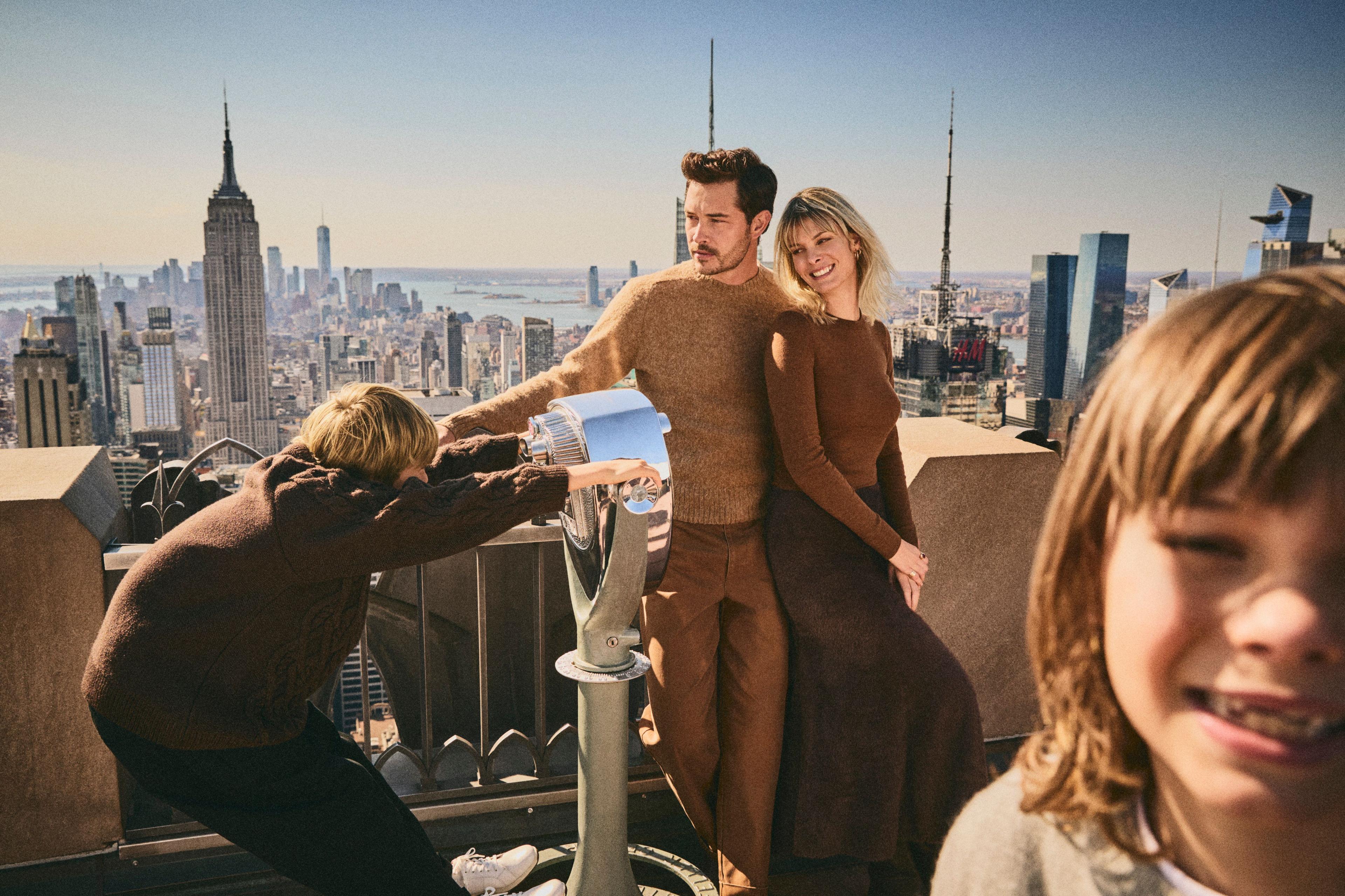 a family smiling looking out at the new york city skyline