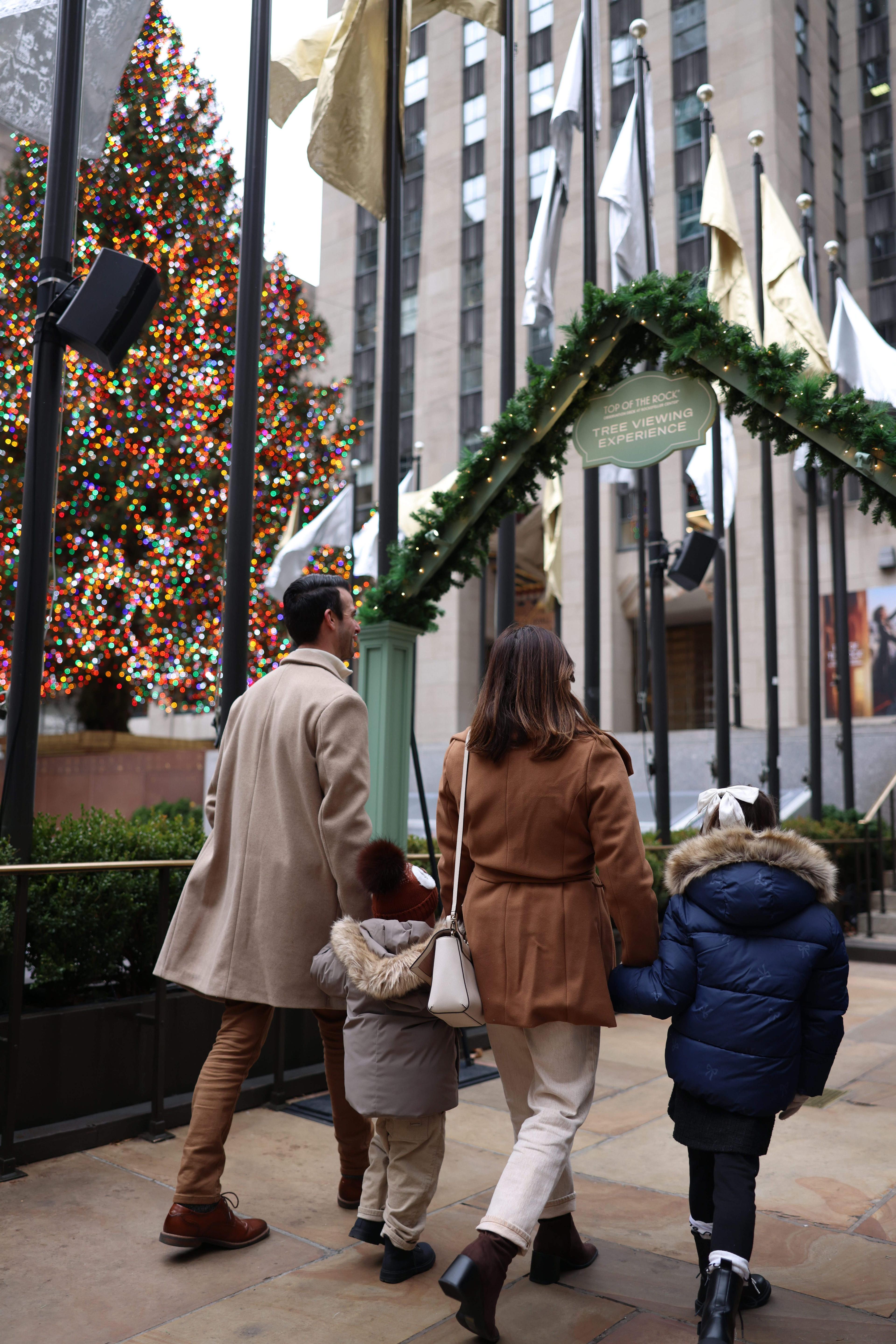 a Family walking towards the Rock Center Christmas Tree