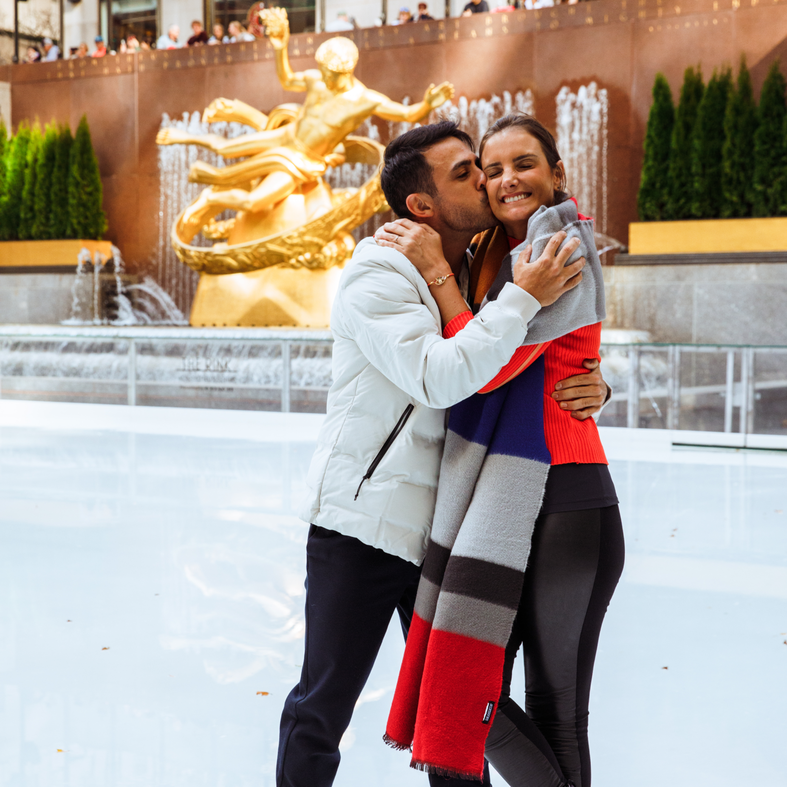 A couple posing for a photo at The Rink at Rockefeller Center