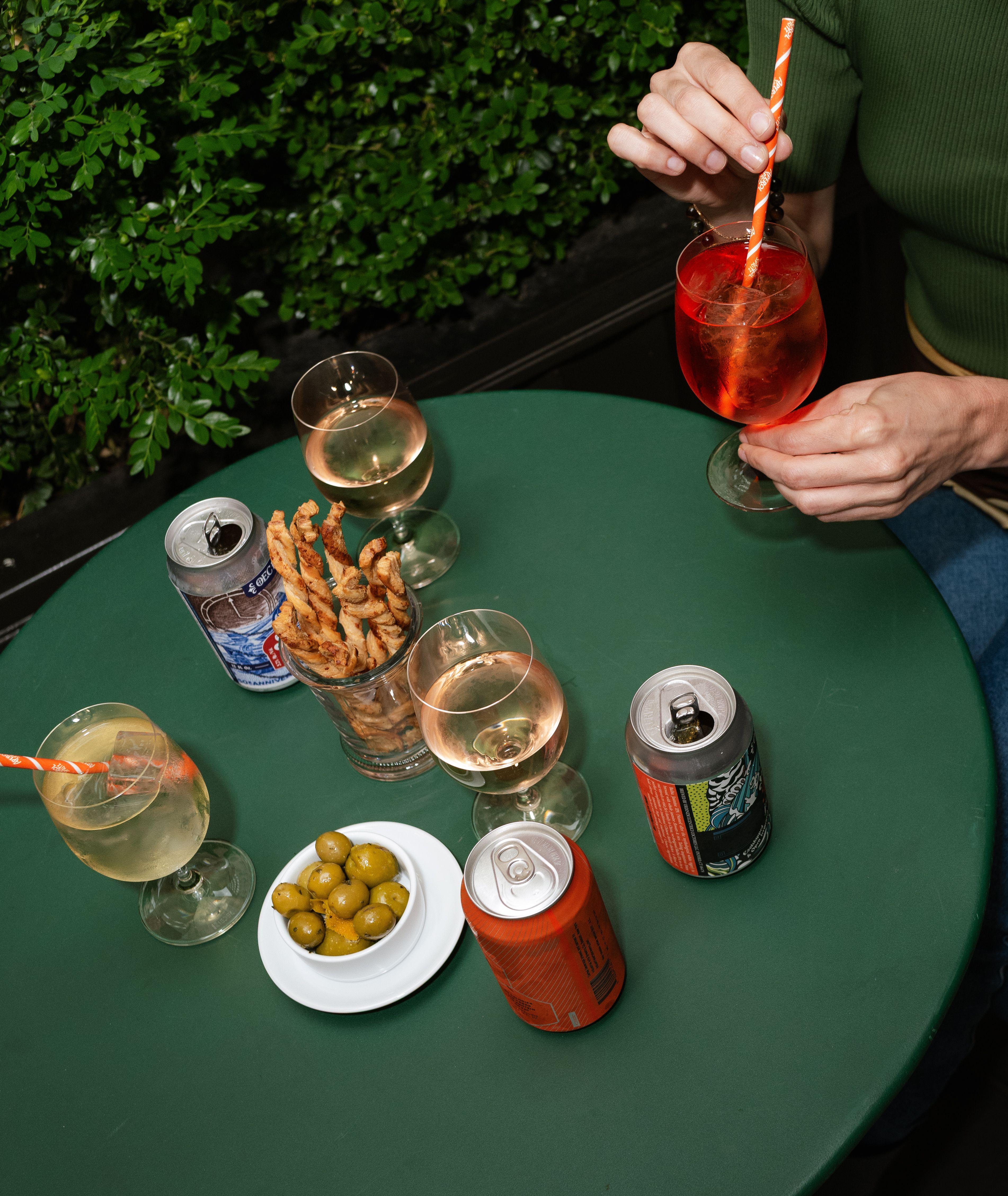 a green table with cocktails and appetizers