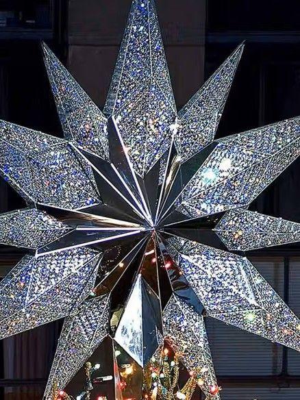 Close-up photo of the Swarovski star atop the Rockefeller Center Christmas Tree, sparkling with crystal facets and lights.