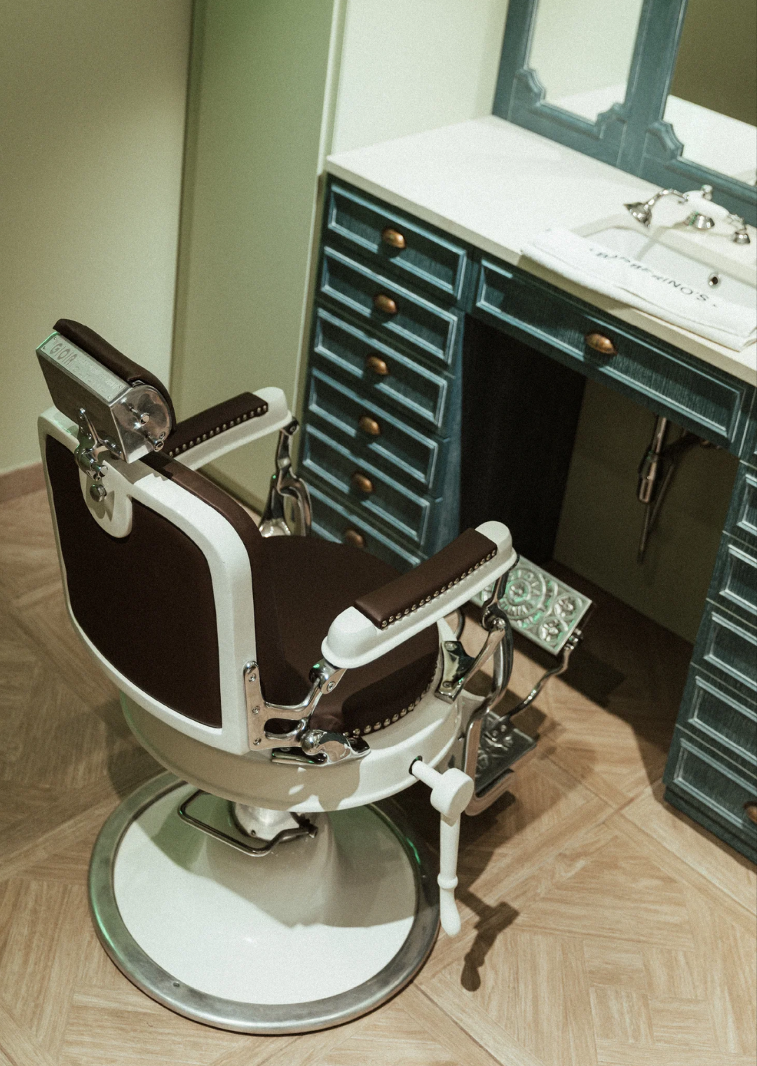 Empty barber chair in front of a vanity desk