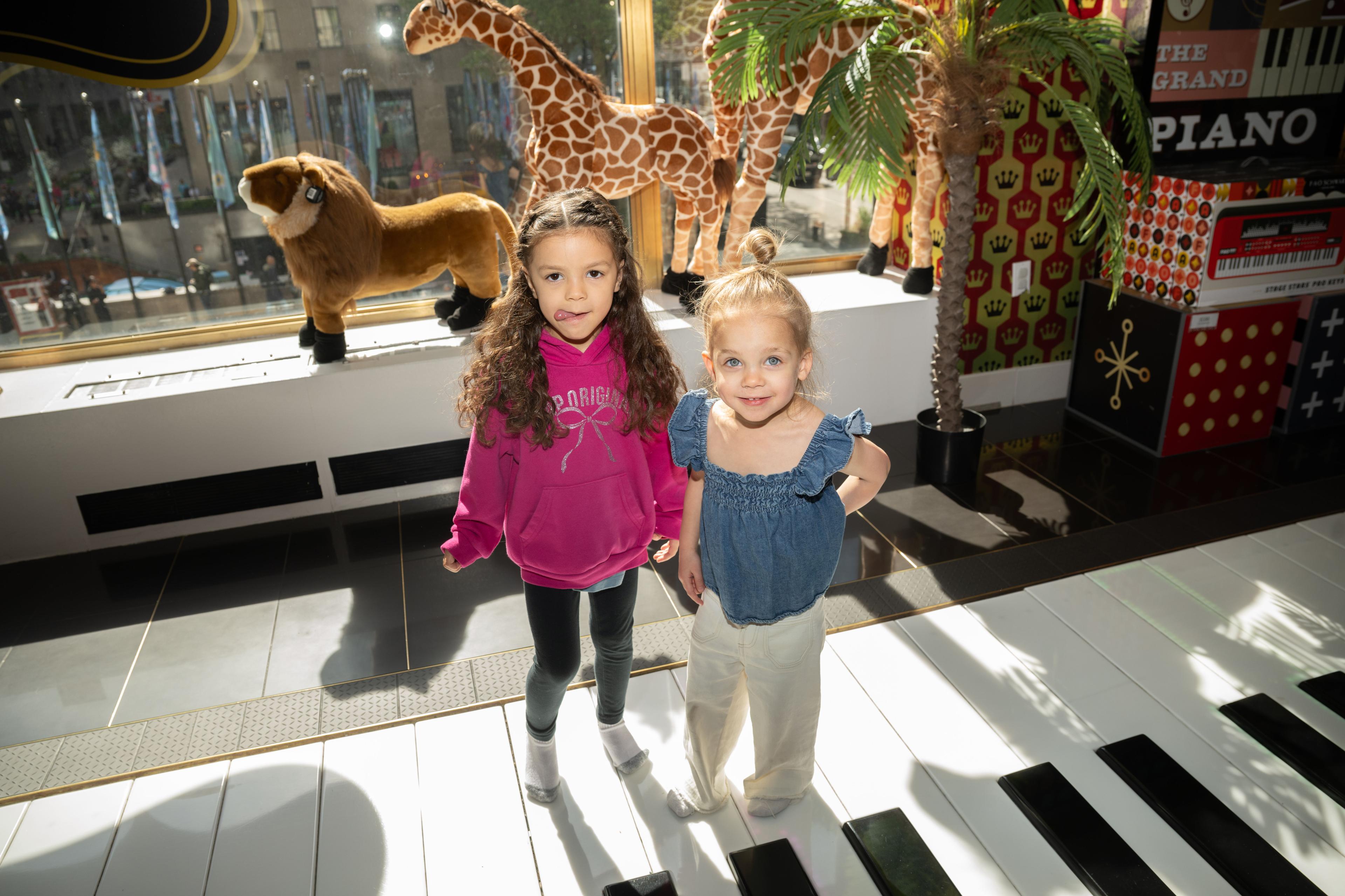 two kids smiling at fao schwarz