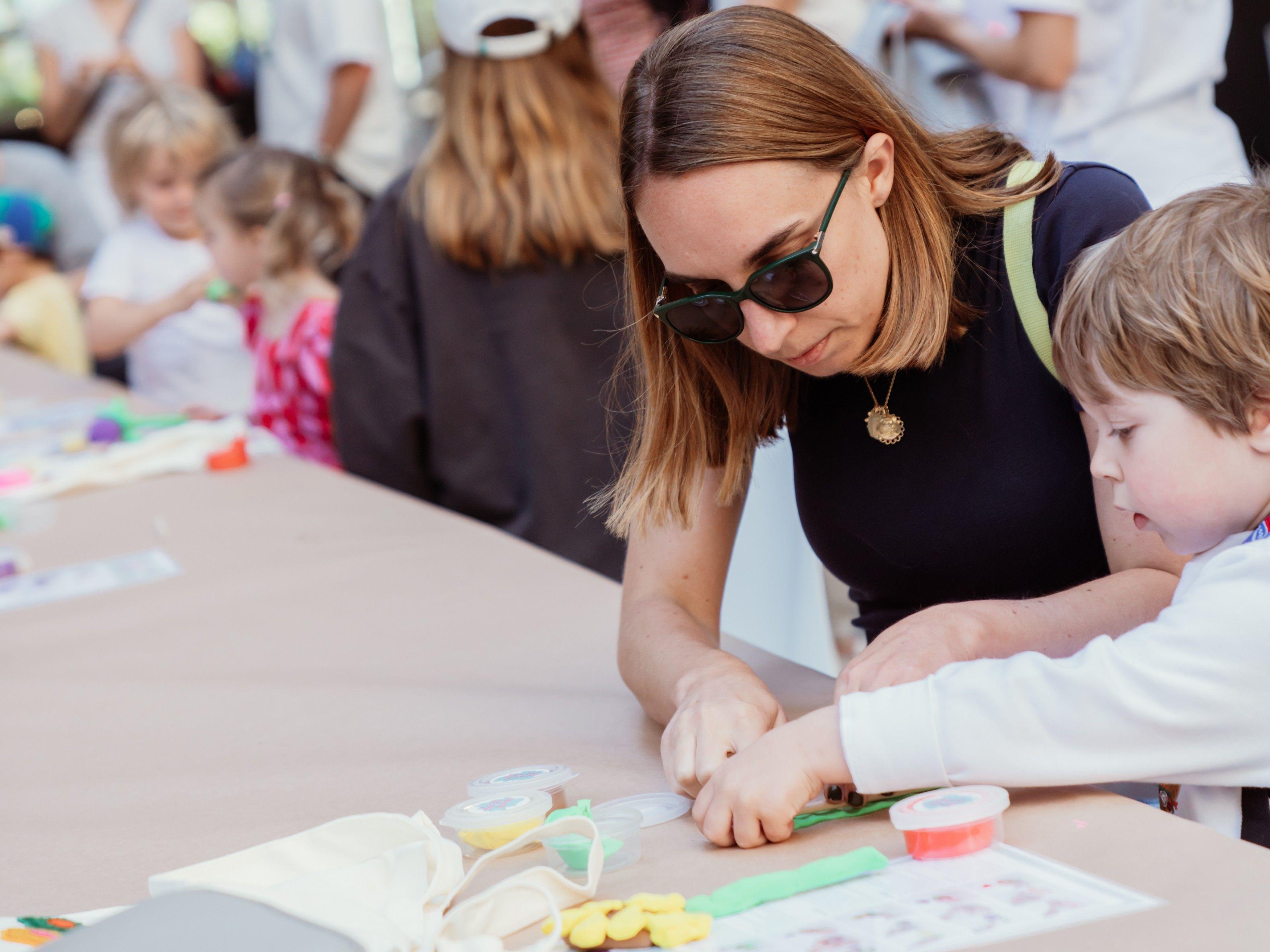 a mother and child doing a craft together at rockefeller center
