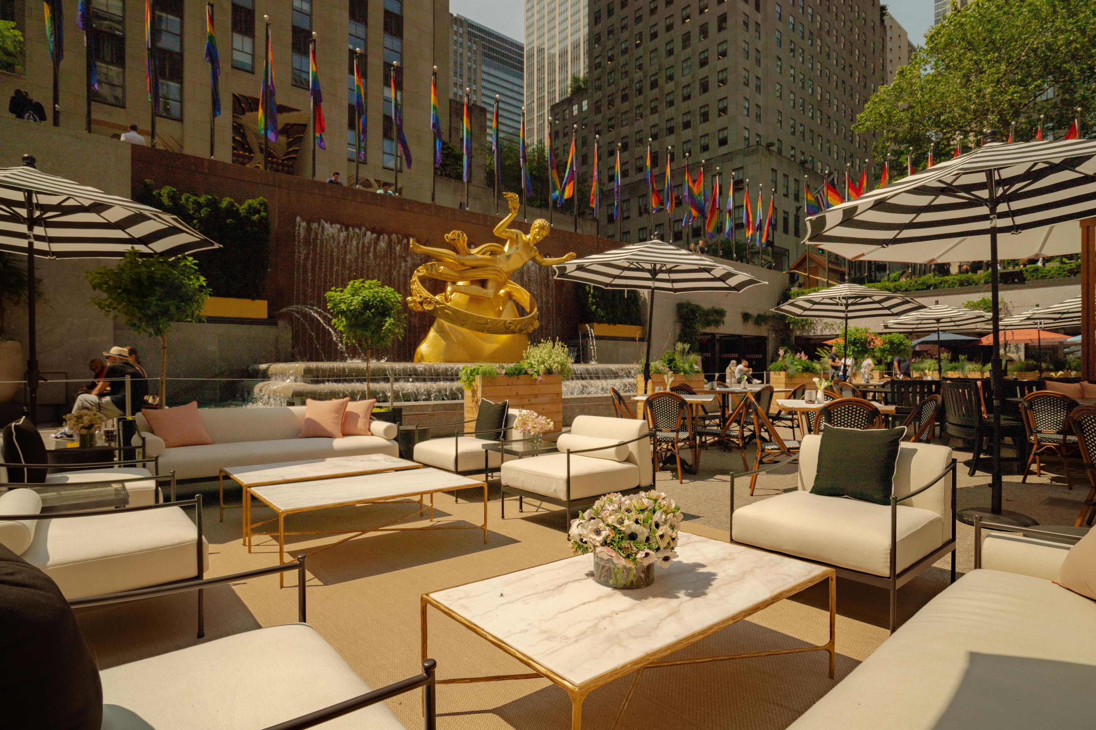 tables and chairs setup with prometheus statue in the background