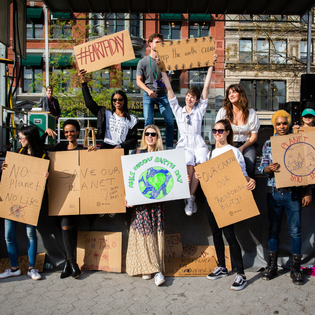 Group of people holding signs celebrating Earth Day
