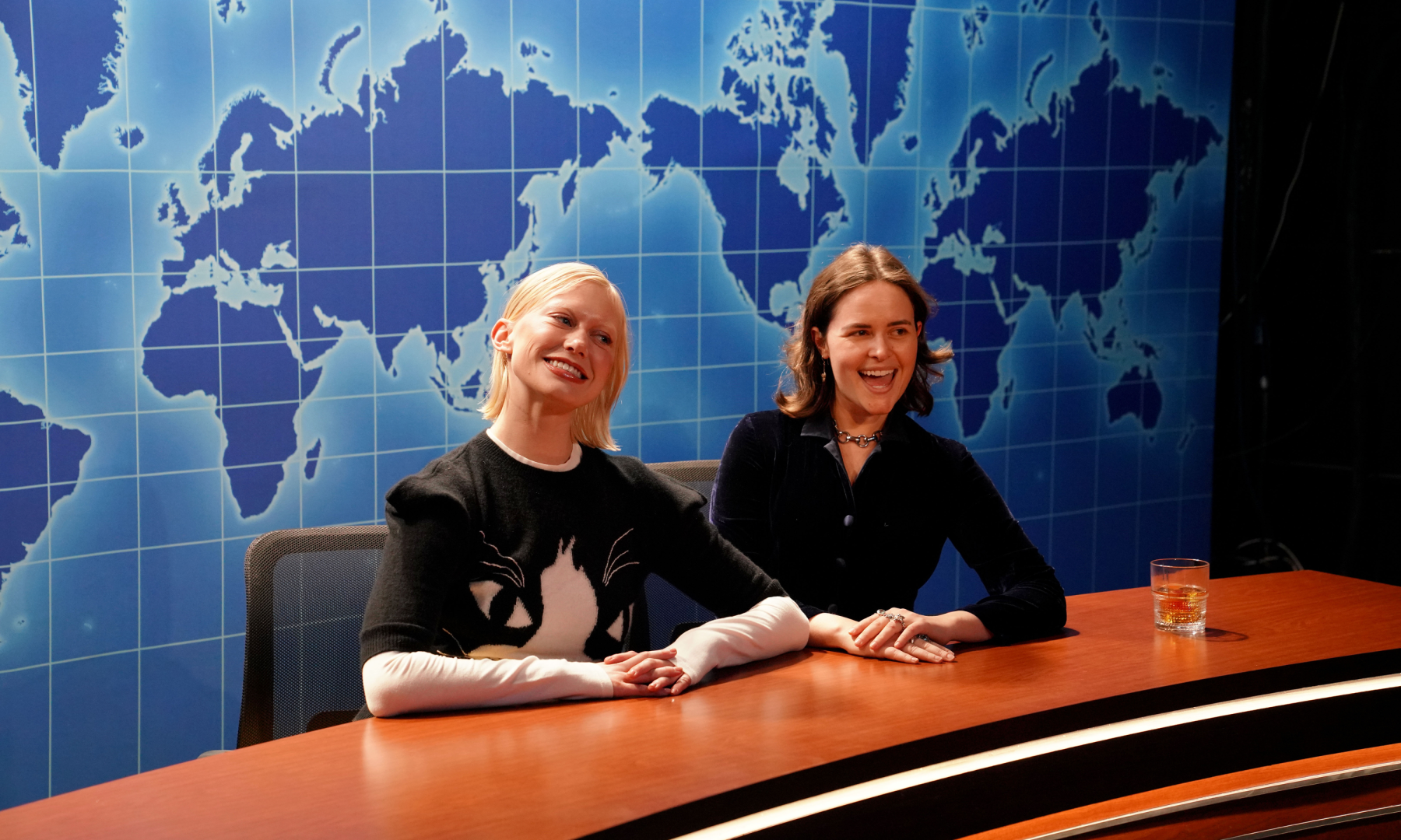 Two women sitting on Saturday Night Live's Weekend Update set at the 'Live from New York: The SNL50 Experience'