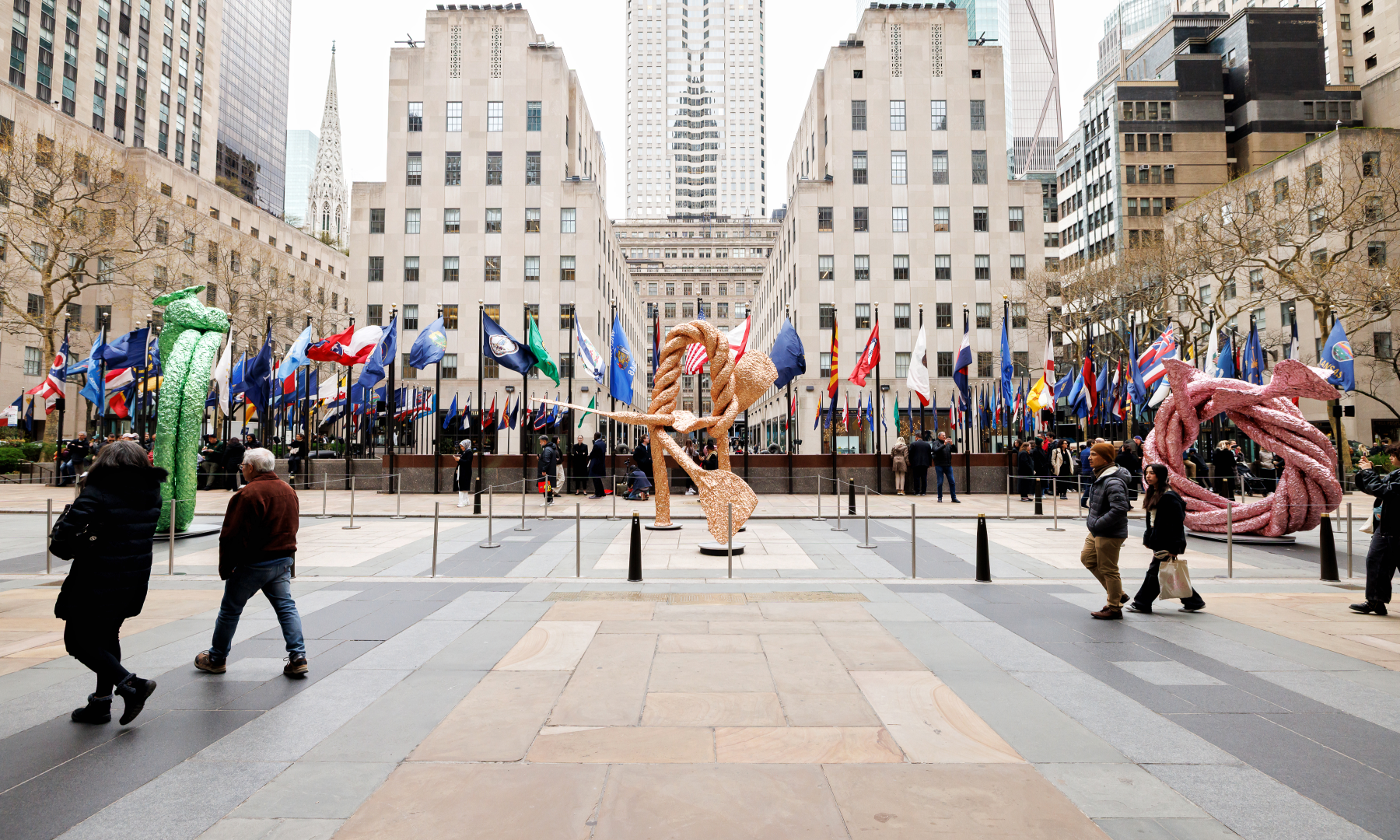 People viewing and walking past three John Chamberlain sculptures on Rockefeller Center's Center Plaza