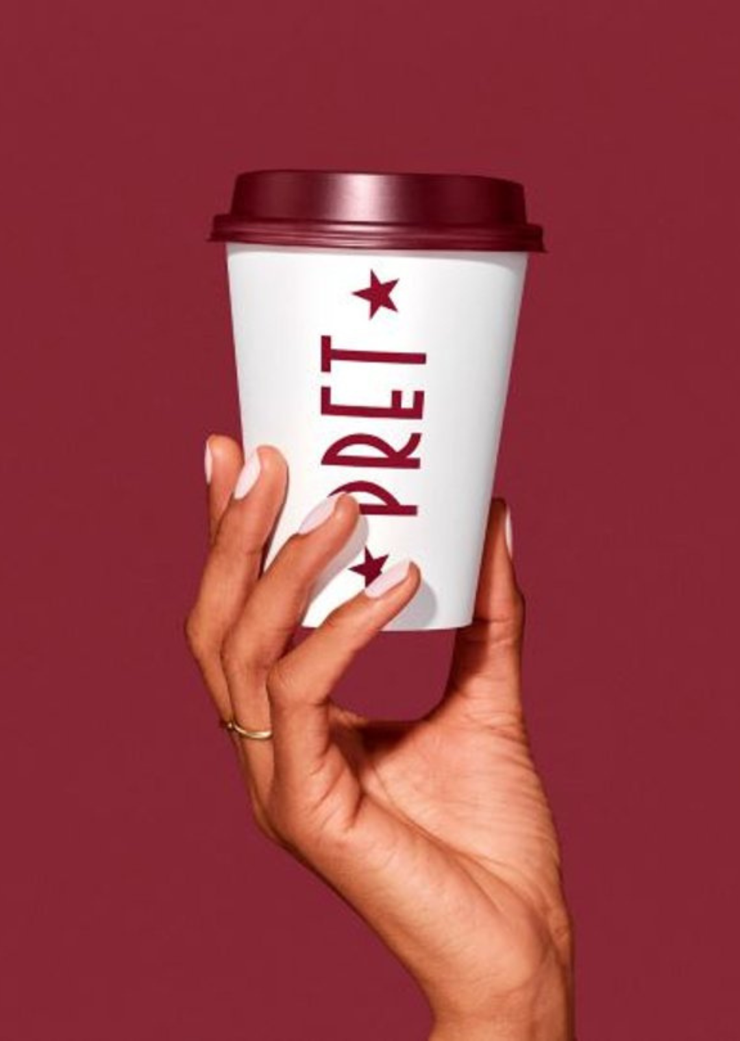 a hand holding a coffee cup