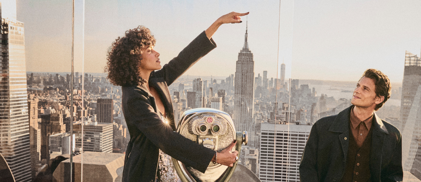 a man and woman smiling at top of the rock