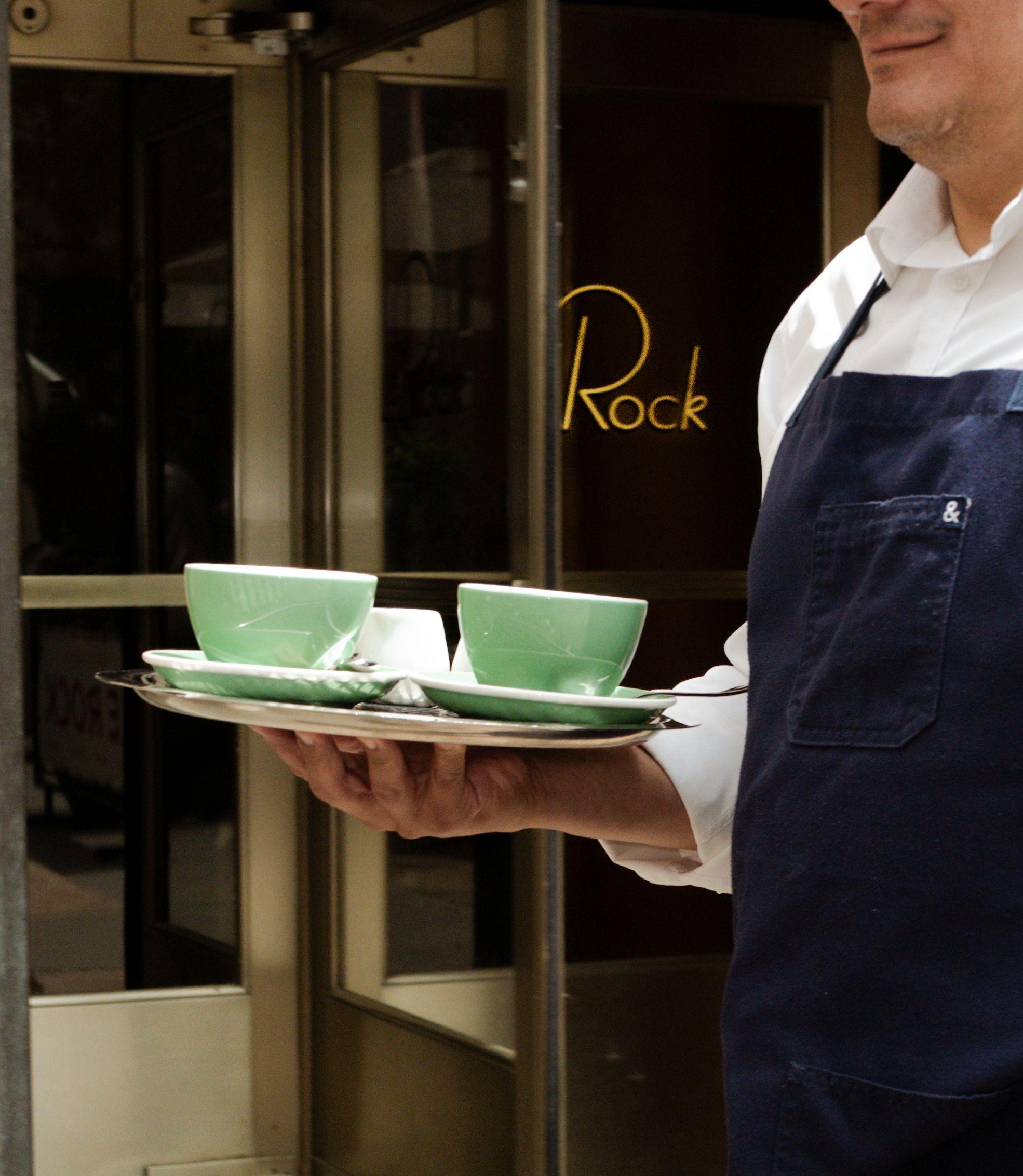 a server carrying two green bowls