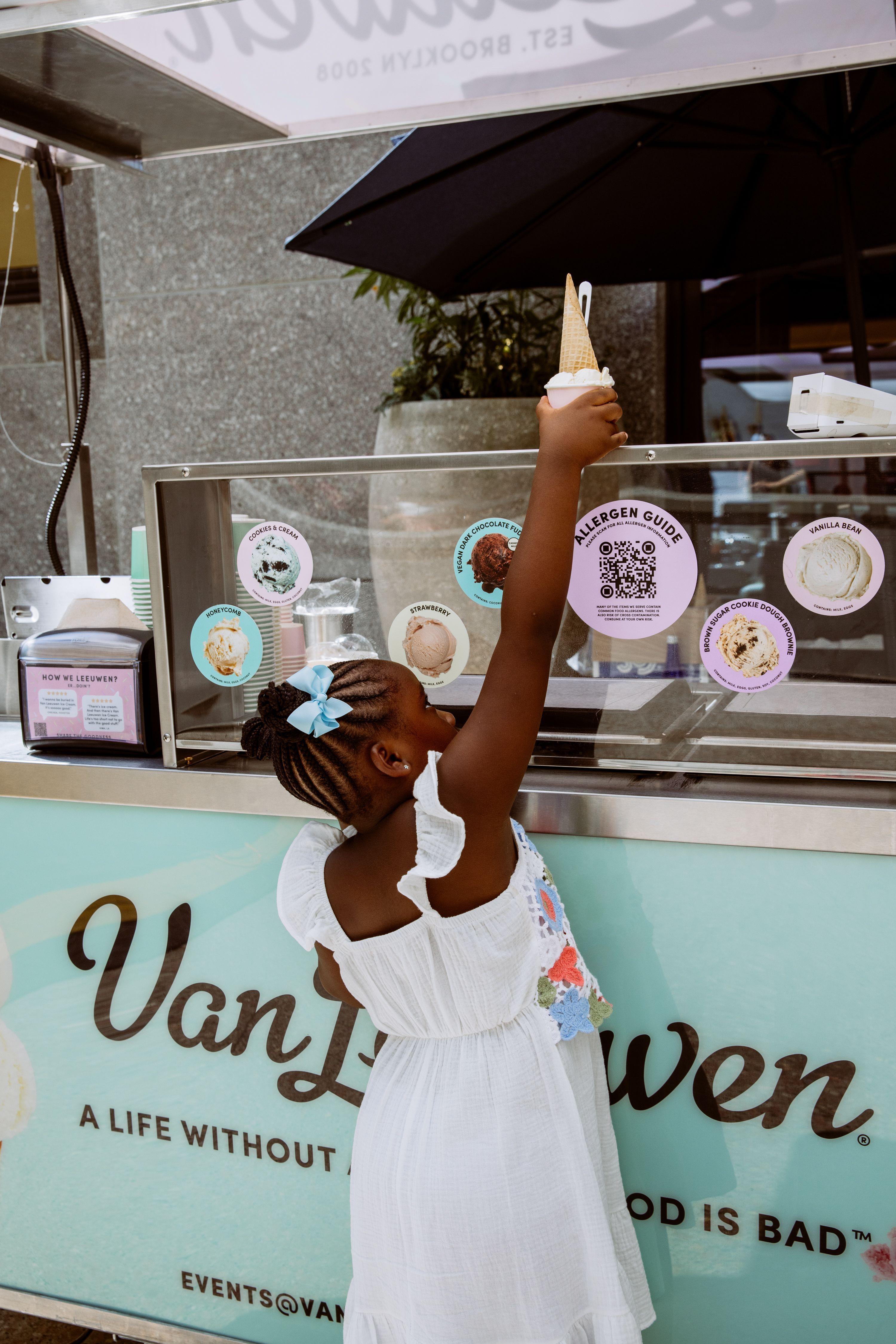 a kid grabbing an ice cream cone