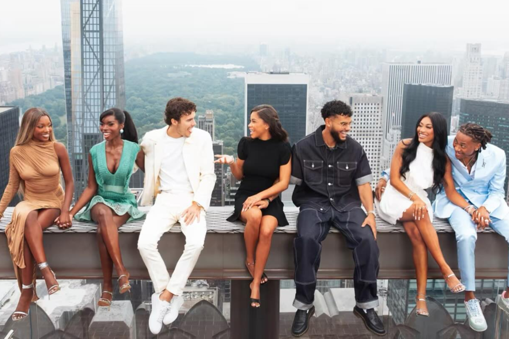 the cast of love island on the beam at top of the rock